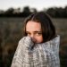 A woman standing and wrapped in a blanket